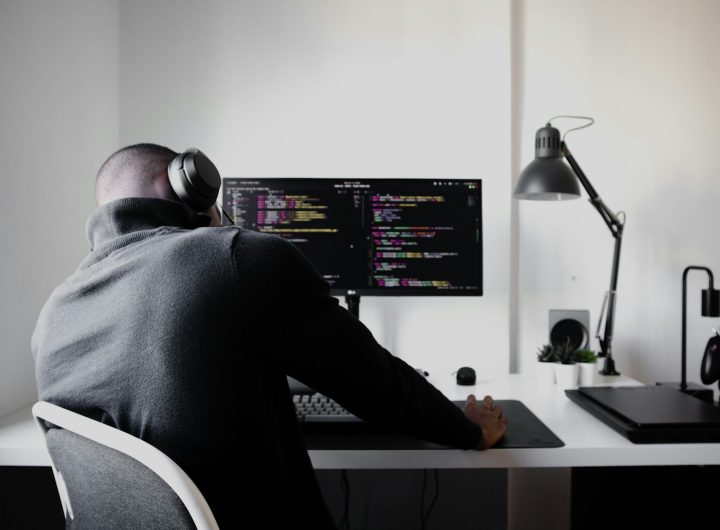 man in black long sleeve shirt sitting on chair in front of computer
